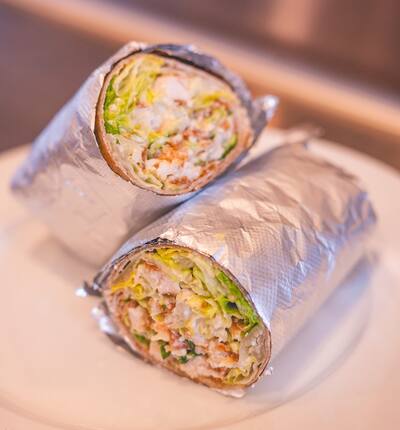 Two chicken Caesar wraps cut in half and wrapped in foil