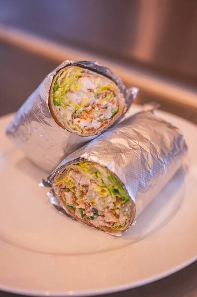 Chicken Caesar wraps cut in half in foil, from the side