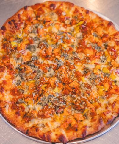 A Cali Buff pizza with buffalo chicken, gorgonzola and yellow hot peppers, seen from above