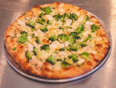 A Chicken and Broccoli pizza, a white pizza with chicken and broccoli, seen from above