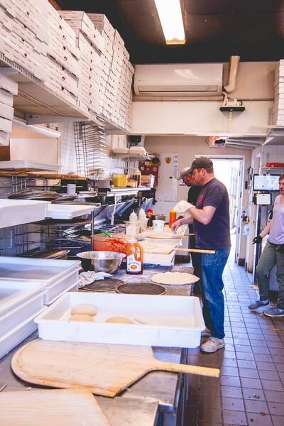 A cook working at the prep counter in the kitchen, seen from down the line