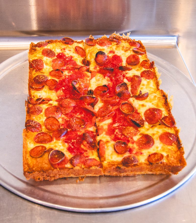 A Detroit style pepperoni pizza with crisp cheese edges