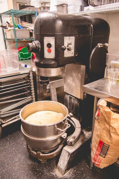 The big dough mixer in the kitchen with a bowl of dough