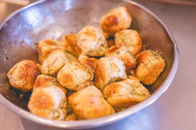 Garlic knots piled in a steel bowl