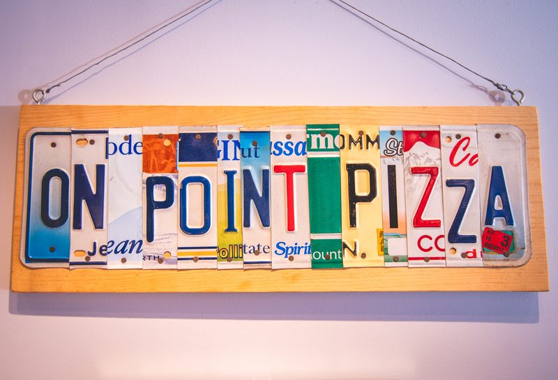 The On Point Pizza sign made of old license plates, inside the shop