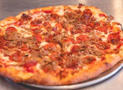 A close look at a Meatlovers pizza with pepperoni and crumbled sausage