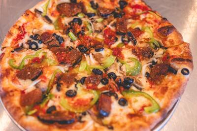 A close look at a Mom's Veggie pizza with eggplant, green peppers and black olives