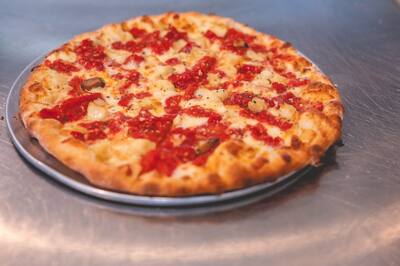 A Roma and Garlic pizza with roasted Roma tomatoes and garlic cloves and a browned crust