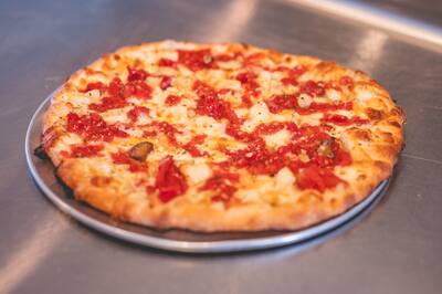 A Roma and Garlic pizza with chopped roasted tomatoes and garlic, from a higher angle