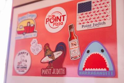 Stickers of Point Judith and Narragansett on a red wall