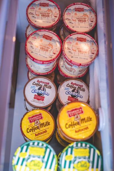 Tubs of Warwick Ice Cream stacked in a cooler, seen from above